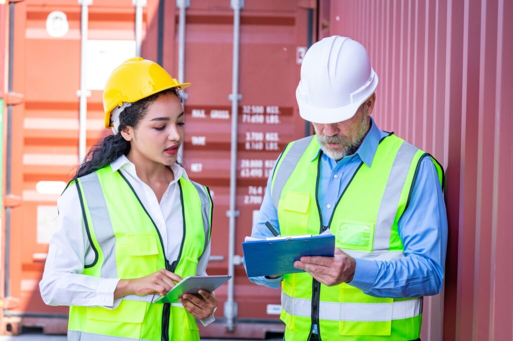 dock worker under discussion about dock container shipping warehouse document ,they wearing safety u